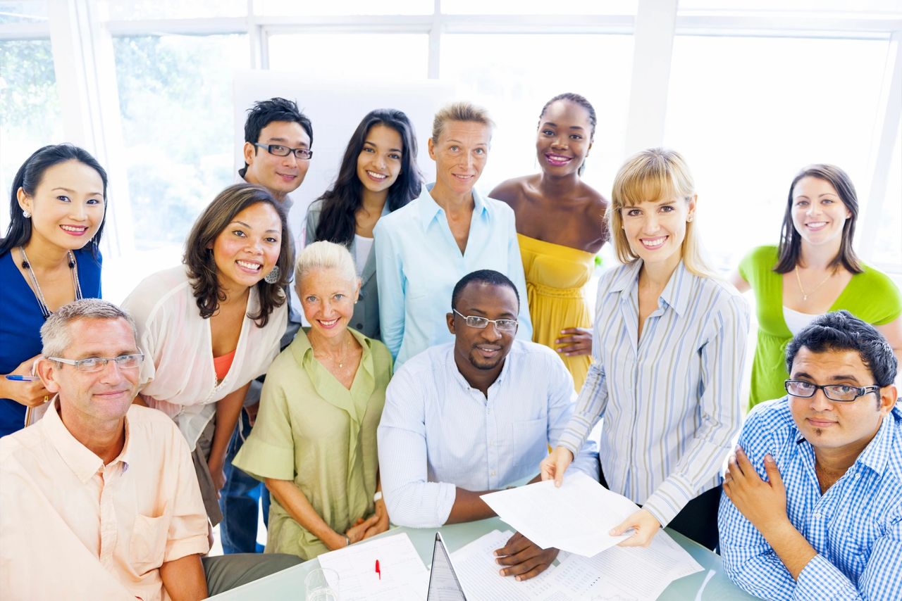 A team stops to take a photo while working on a project that they collectively work on to achieve accomplishments and growth.