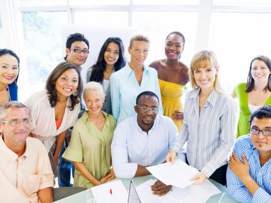 Diverse group of people smiling at a meeting.