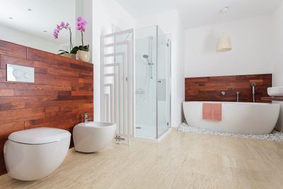 Modern bathroom with wooden accents and a glass shower enclosure.