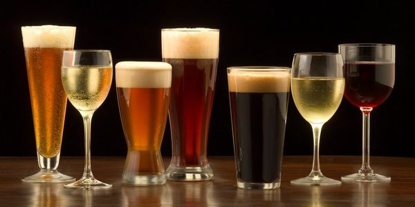 Beer and wine glasses full on a table.