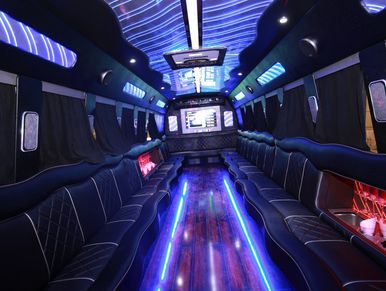 Luxurious limousine interior with neon blue lighting and leather seats.