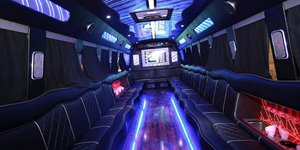 Luxurious limousine interior with blue LED lighting and leather seats.