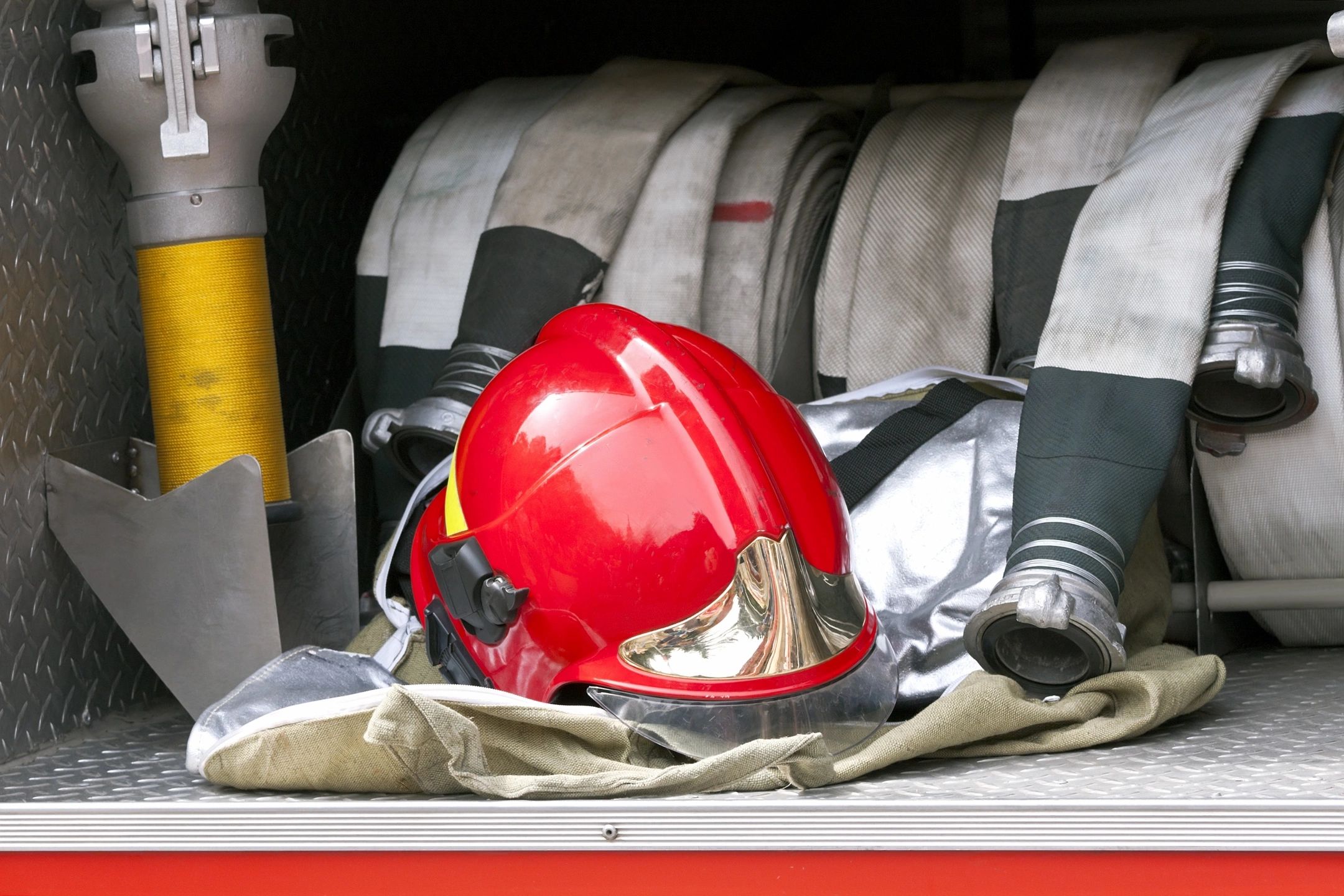 Firefighter gear including a red helmet and hoses.