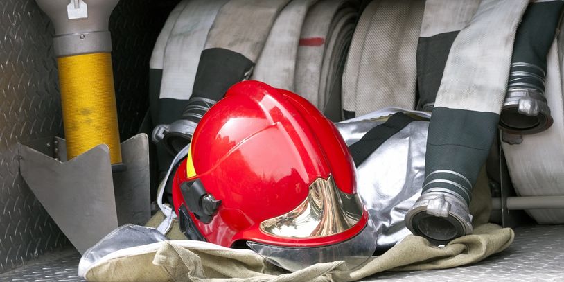 Firefighter gear including a red helmet and hose.