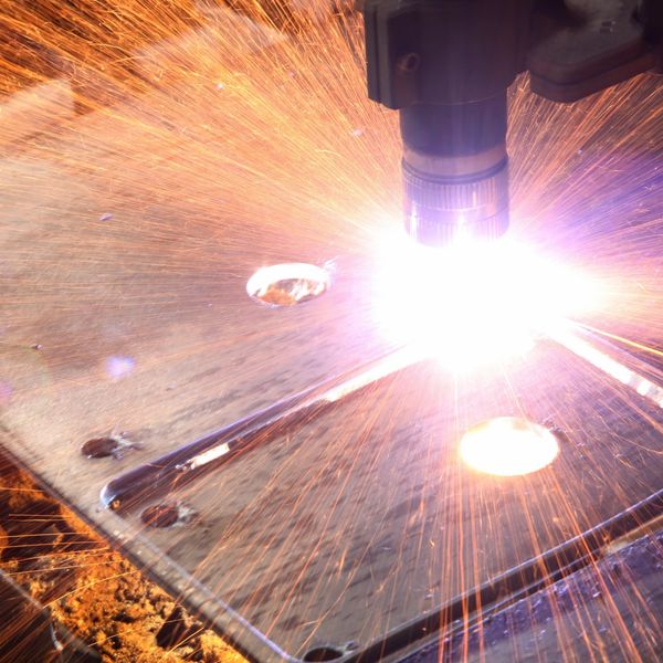 Close-up of a metal cutting process with sparks flying.