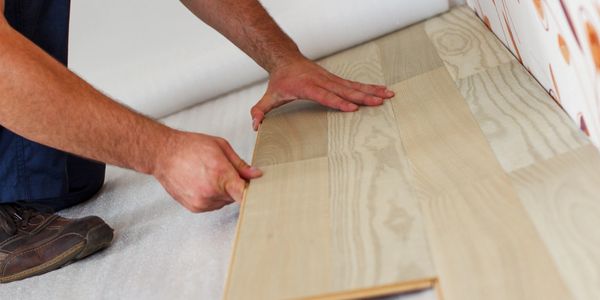 Craftsman installing new hardwood floors.