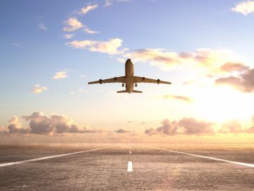 Airplane taking off at sunrise.