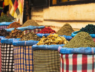 Colorful sacks filled with various spices and herbs at a market.