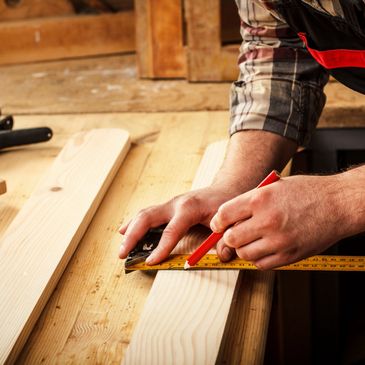 man with a pencil making a mark on a board with a square