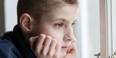Male child staring out a window