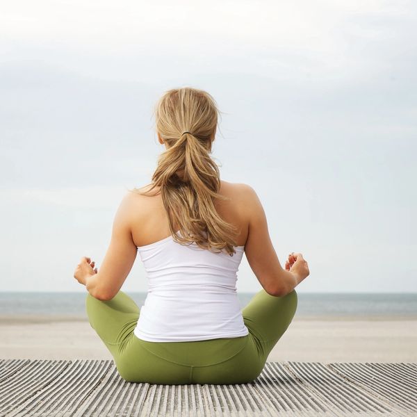 Woman sitting in yoga pose outdoors.