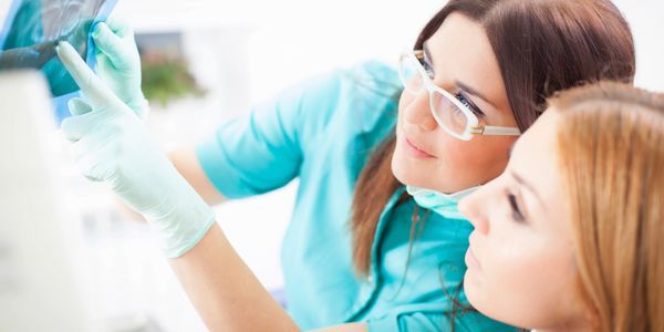 The dentist is showing the patient her X-ray.