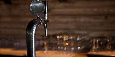 Close-up of a beer tap in a bar setting.