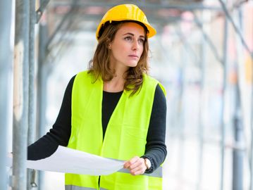 woman wearing yellow safety vest over black long sleeve shirt with yellow hard hat by Alpha Embroide