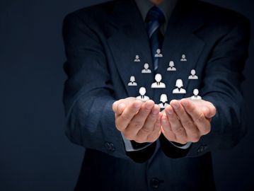 Businessman holding digital icons representing a network of people.