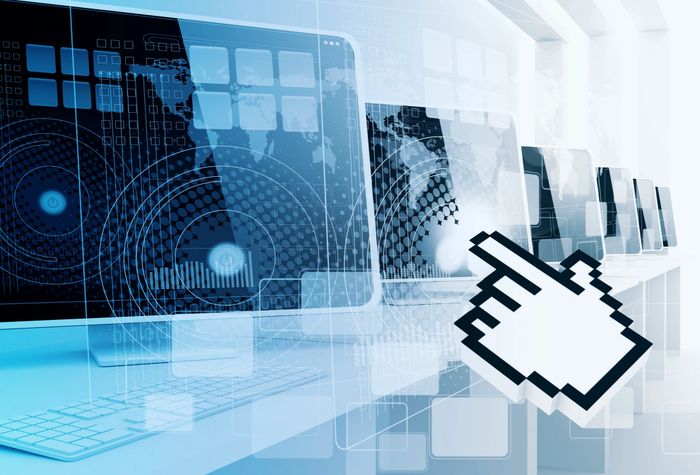 Digital cursor pointing at futuristic computer screens with tech overlays.