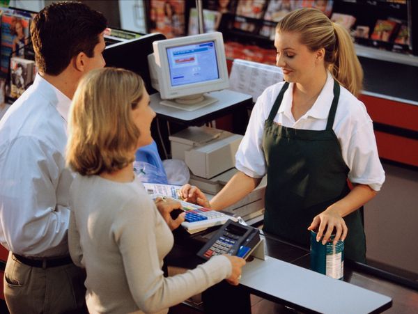 Cashier assisting customers at checkout.