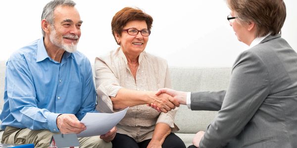 An elevator saleswoman working with and elderly couple.