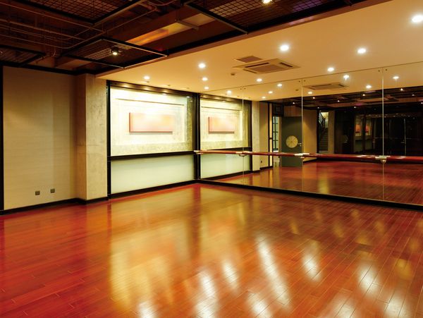 Empty dance studio with wooden floors and mirrored walls.