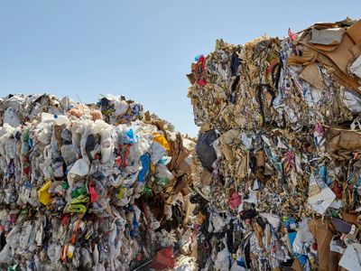 Large bales of compressed recyclable materials under a clear sky.