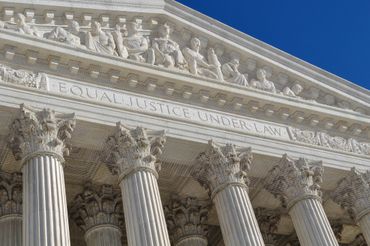 Columns and inscription on a classical courthouse facade.