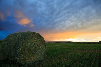 Idaho sunset over a field of hay.  Hay bail is in the picture.