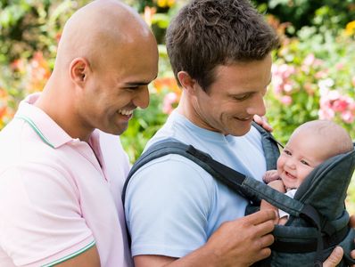 Dads smiling at their baby, symbolizing their experience during our two-week sleep consultation.