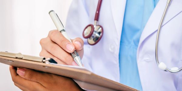 Photo of doctor writing on a tablet