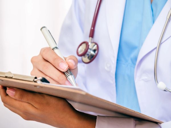 Doctor writing on a clipboard.