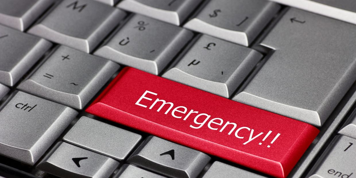 Red emergency key on a gray computer keyboard.