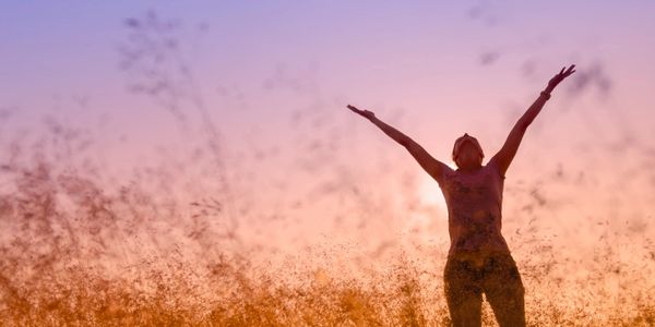 person feeling free looking up to sky with arms outstretched