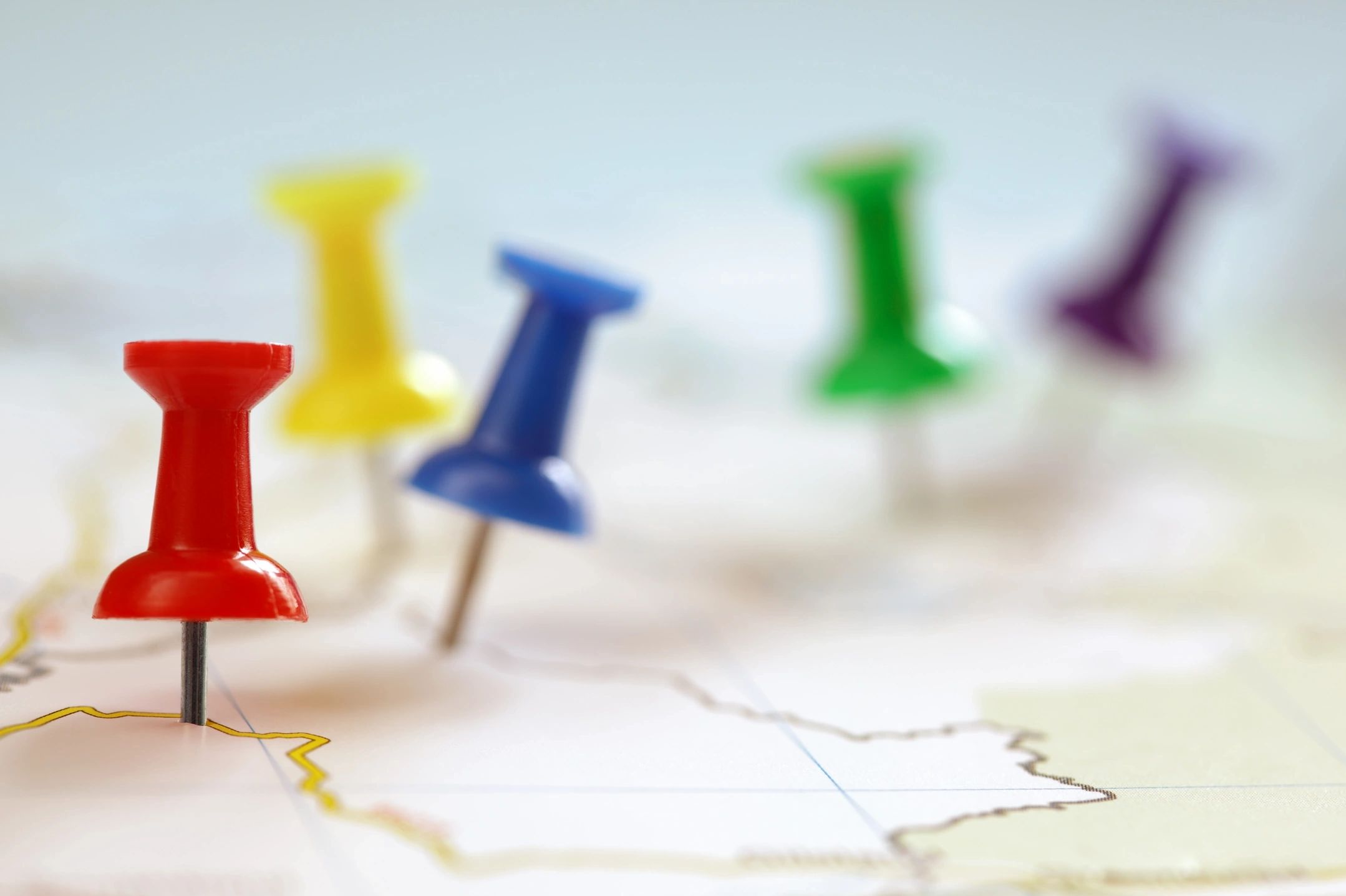 Colorful push pins marking locations on a map.