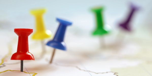 Colorful push pins marking locations on a map.