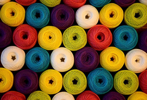 Colorful yarn balls arranged in rows.
