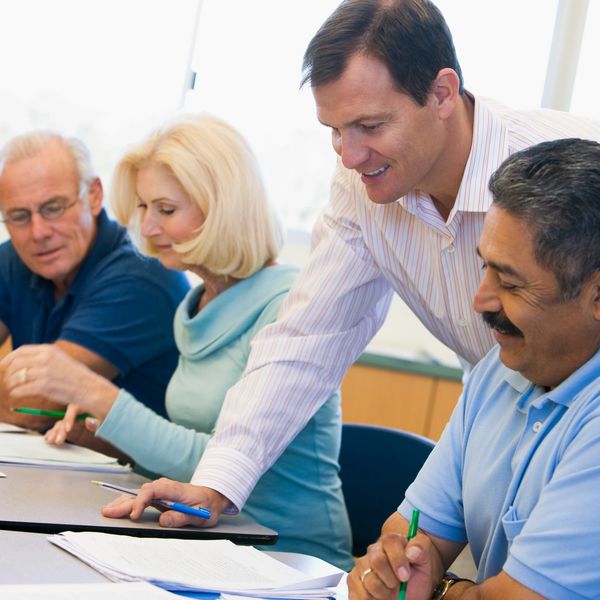 Group of people smiling while reviewing paperwork.