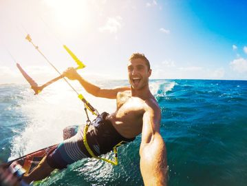 Up close selfie of a kitesurfing riding the wind and waves