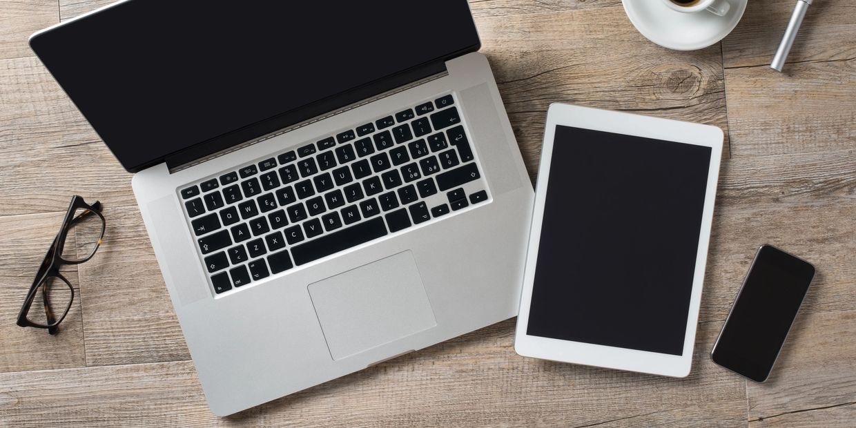 Photo od desk with laptop, tablet, and a phone