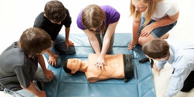 Plusieurs secouristes effectuant des compressions thoraciques sur un mannequin de RCR.