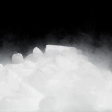 Dry ice producing fog over black background.