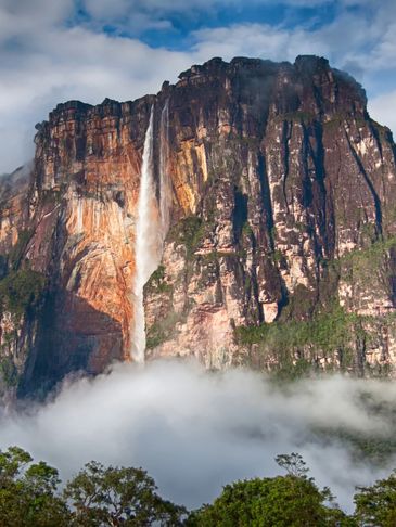 A Rocky Cliff with a Steep, Tall Waterfall Descending into Fog