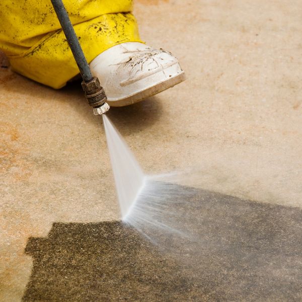 This is a floor being cleaned with a pressure washer. 