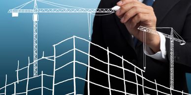 Man drawing a building and a crane on a clear whiteboard