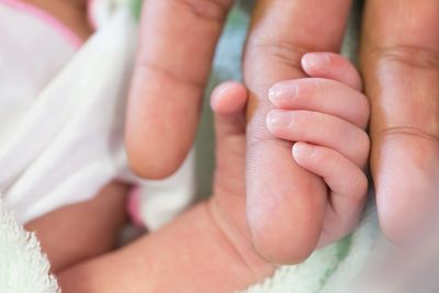 Infant holding parent's finger