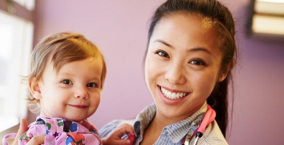 A happy baby and her babysitter smiling.