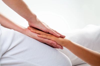 A man holding woman's hand in his two hands