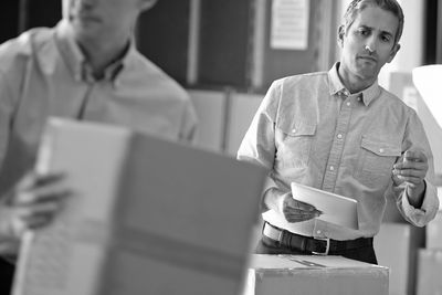 Person checking and counting cartons in warehouse.