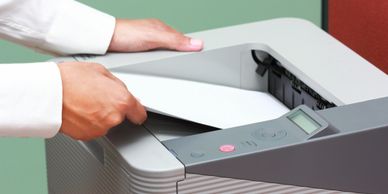 A man at the printer collecting printed reports