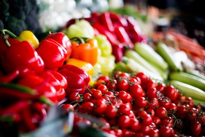 A colorful display of fresh vegetables including tomatoes, bell peppers, and zucchini.