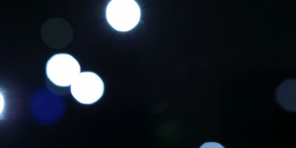 Blurred bright white and blue lights on a dark background.