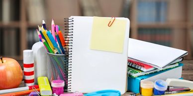 A collection of colorful stationery and notebooks on a desk.
